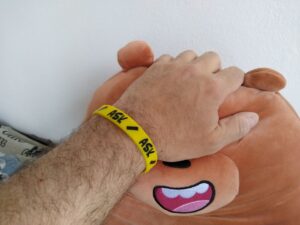 Yellow silicone "Ask" consentband on a wrist