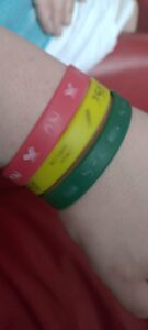 Photo of red, green, and yellow Consentbands with their printing partially worn away