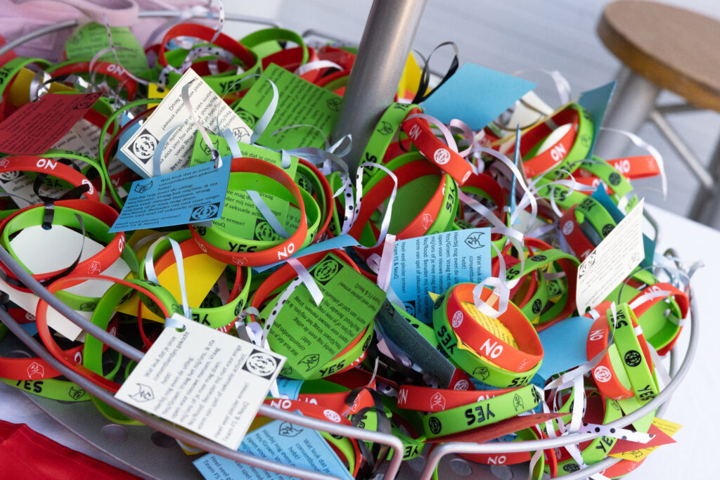 Basket of custom consent bands for FS/Neuq in red and green, with tags attached